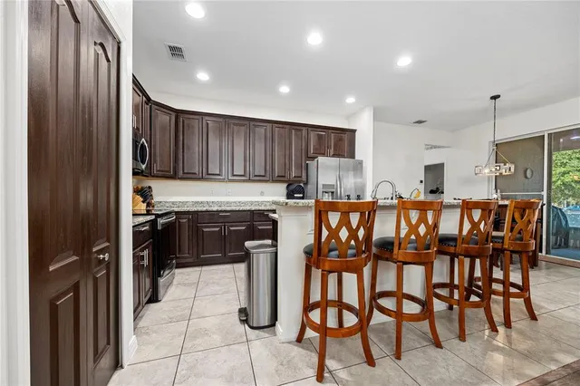 a kitchen with granite countertop stainless steel appliances a refrigerator and microwave