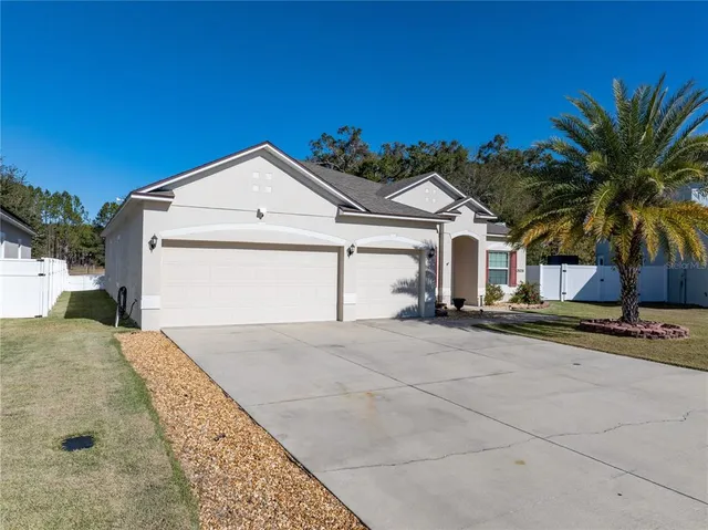 a view of a house with a yard and road