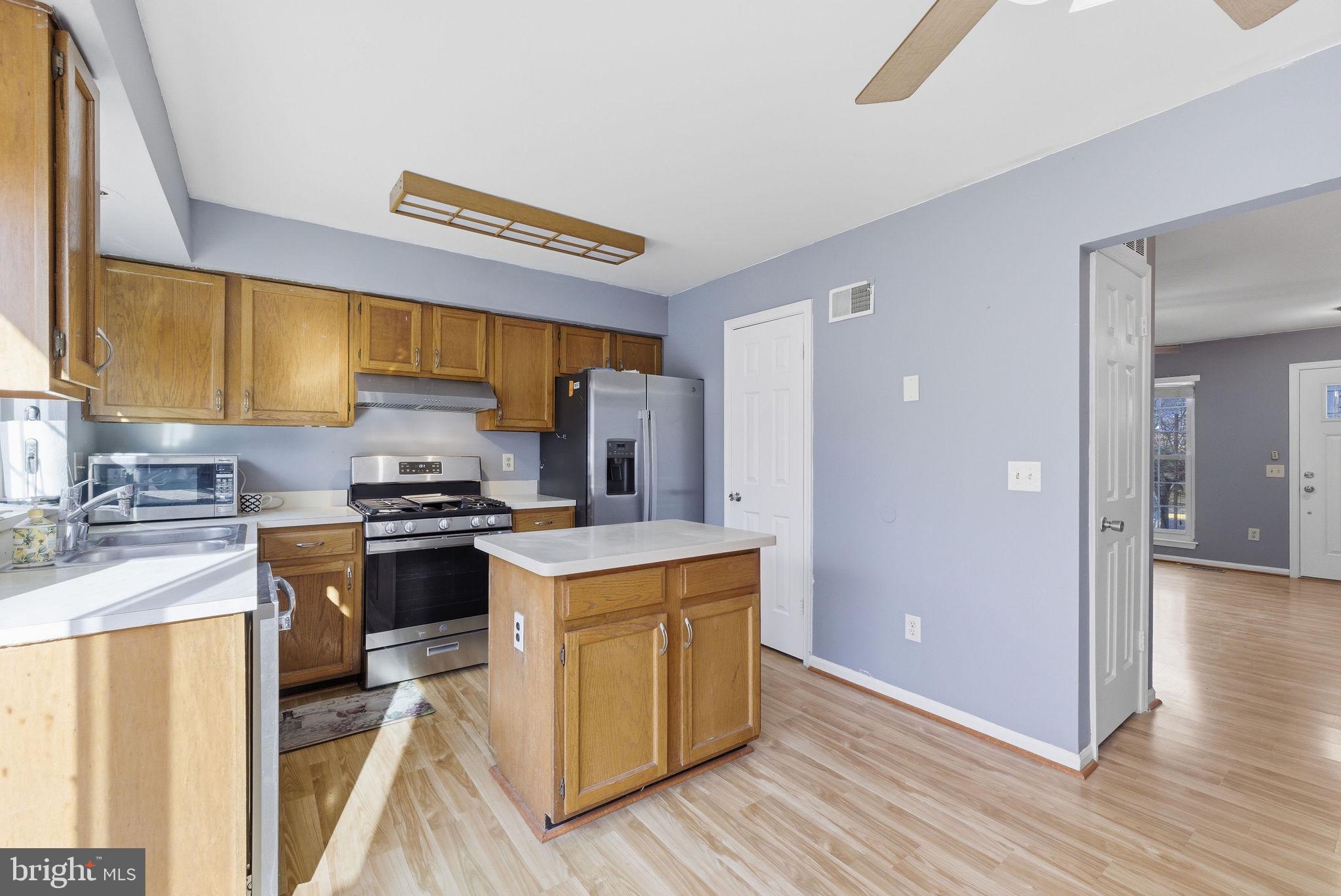 14688 Basingstoke Loop Centreville, VA 20120 - Photo 11 of 34 a kitchen with stainless steel appliances granite countertop a stove a sink and a refrigerator