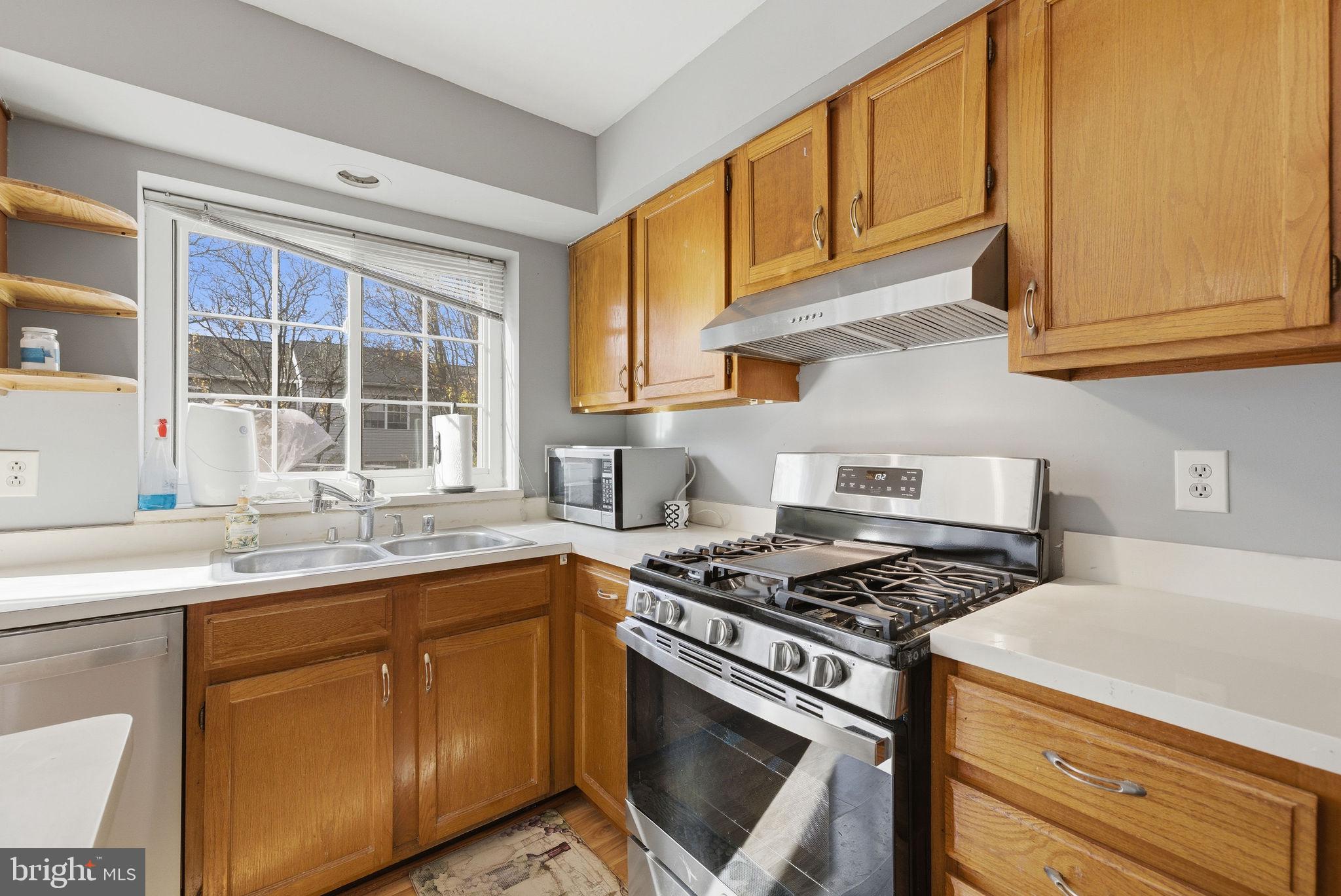 14688 Basingstoke Loop Centreville, VA 20120 - Photo 13 of 34 a kitchen with stainless steel appliances granite countertop a sink a stove and a microwave