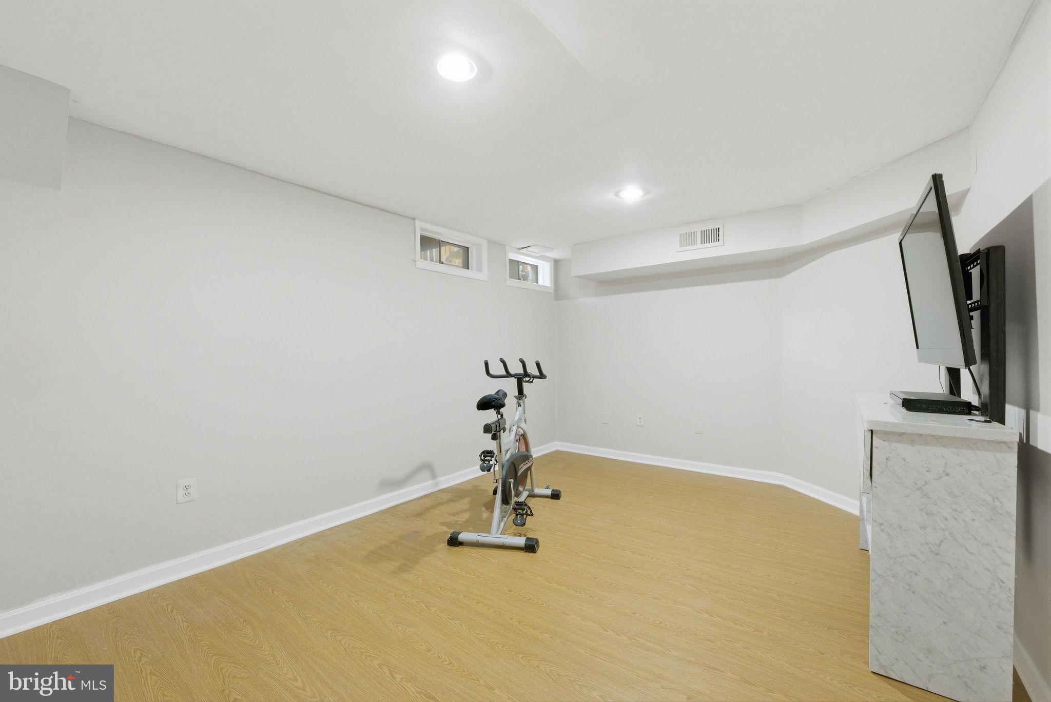 14688 Basingstoke Loop Centreville, VA 20120 - Photo 28 of 34 a room with gym equipment and a flat screen tv