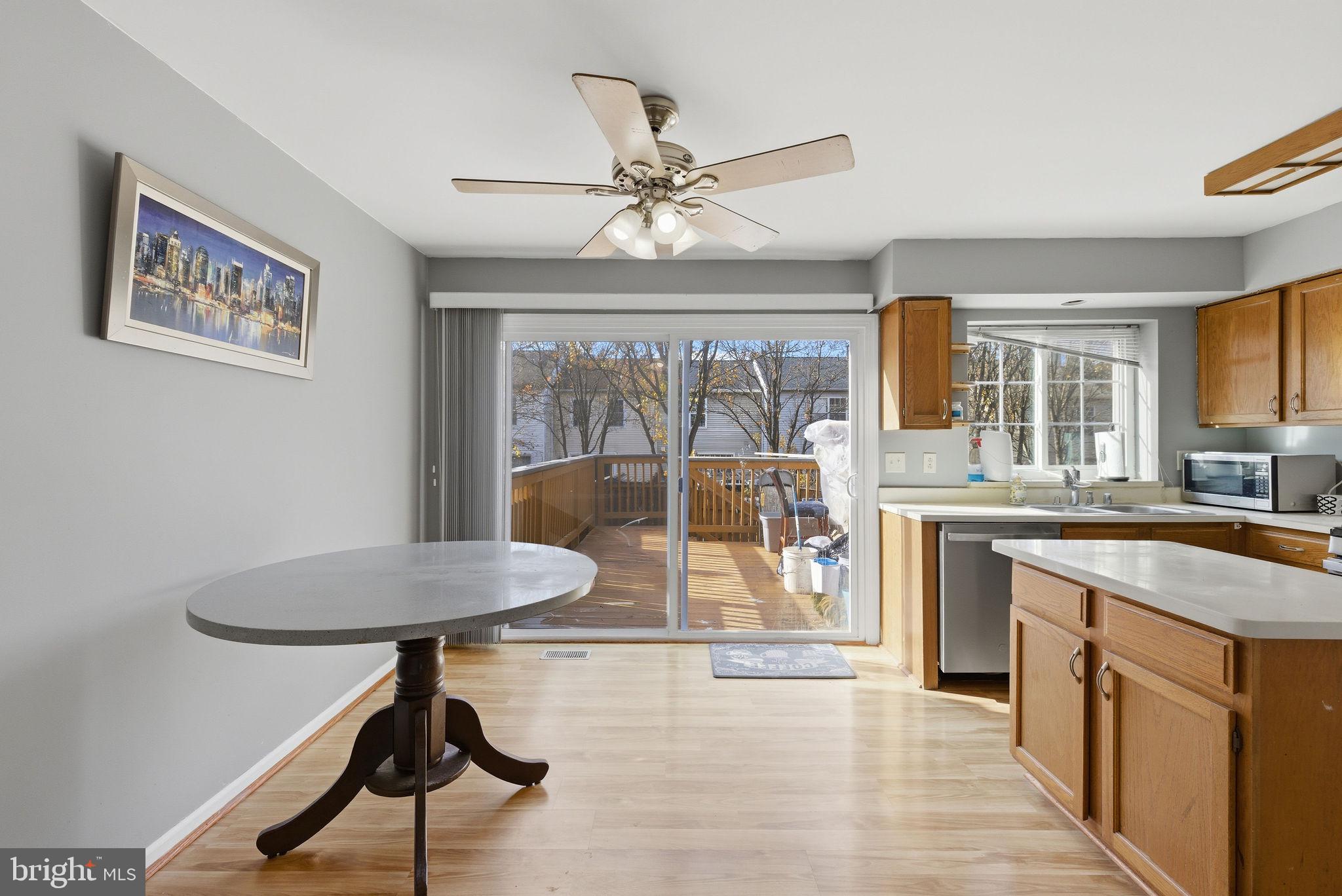 14688 Basingstoke Loop Centreville, VA 20120 - Photo 8 of 34 a kitchen with stainless steel appliances granite countertop a refrigerator a stove a sink a dining table and chairs with wooden floor