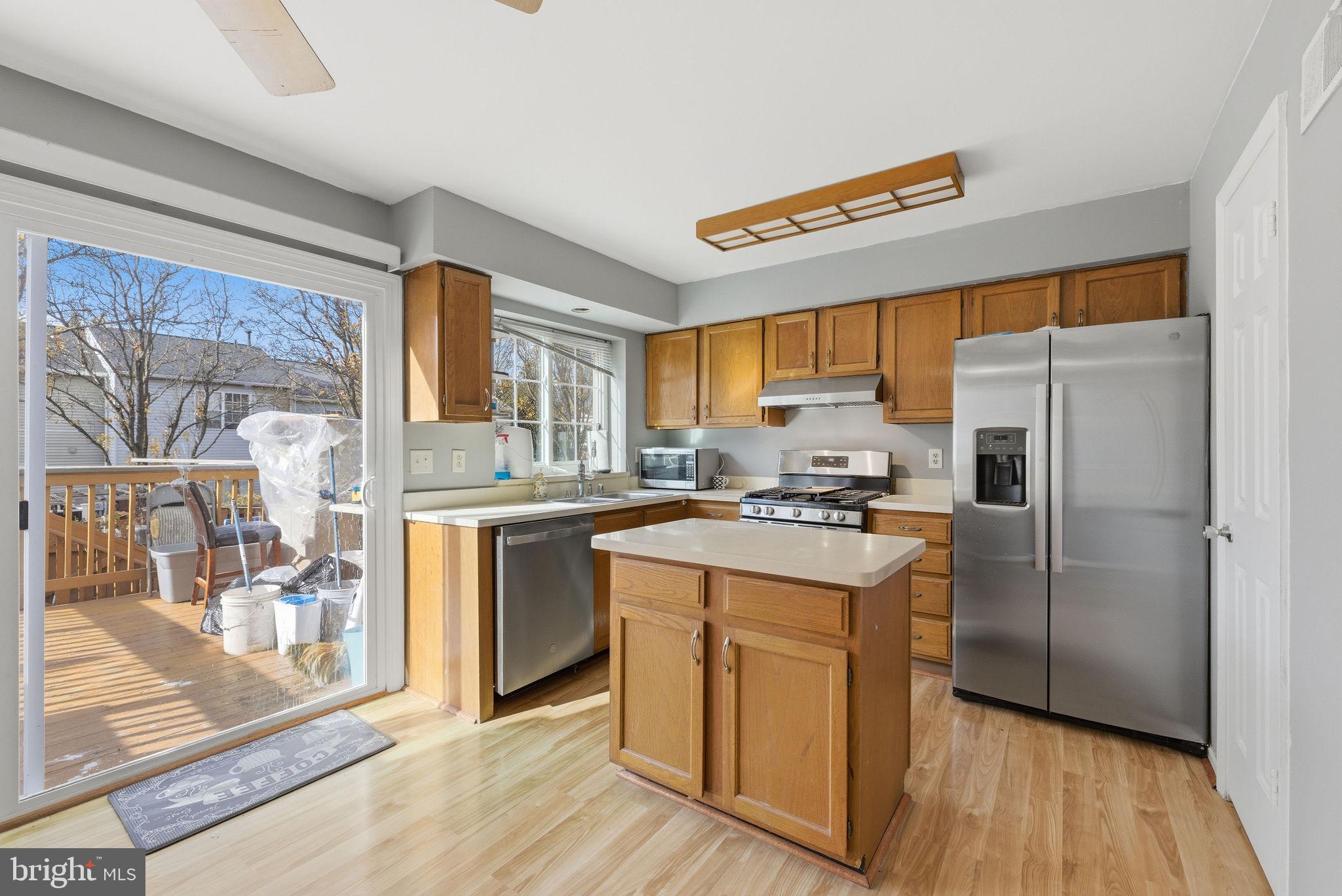 14688 Basingstoke Loop Centreville, VA 20120 - Photo 9 of 34 a kitchen with a refrigerator a sink dishwasher and a stove with wooden floor