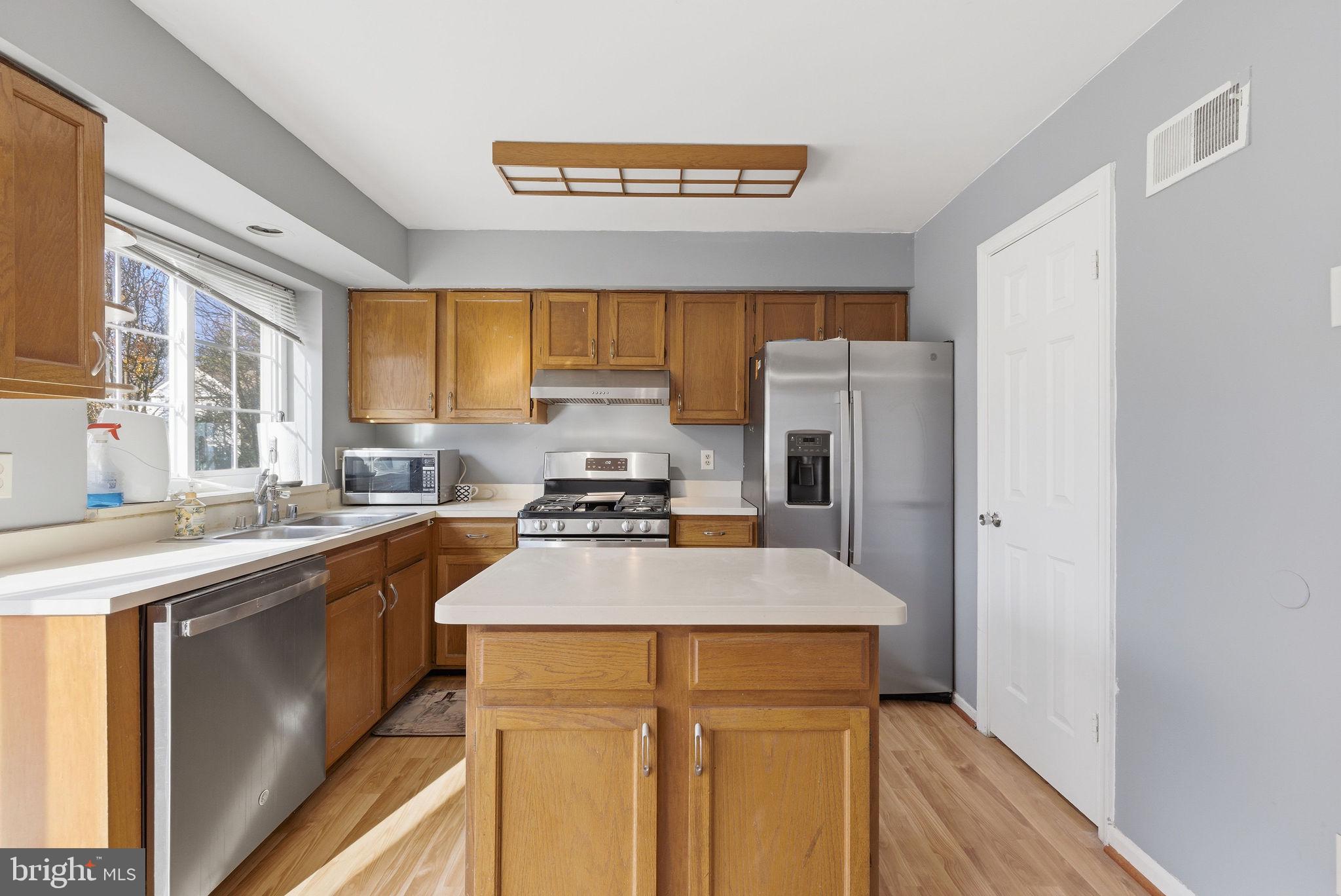 14688 Basingstoke Loop Centreville, VA 20120 - Photo 10 of 34 a kitchen with a sink a stove a refrigerator and a window
