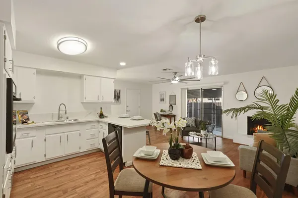 a view of a dining room with furniture a chandelier and wooden floor