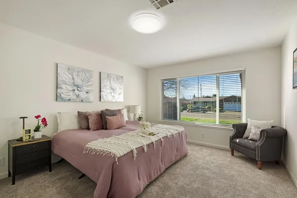 a bedroom with a bed and a couch next to a window
