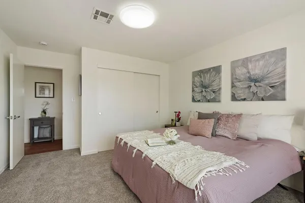 a bedroom with a bed and a painting on the wall