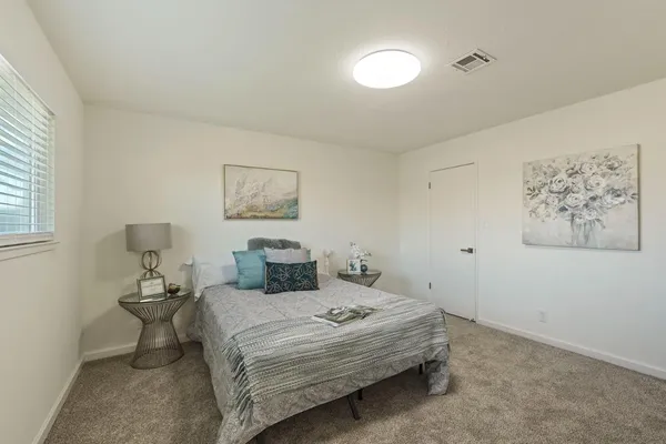 a bedroom with a bed and a painting on the wall