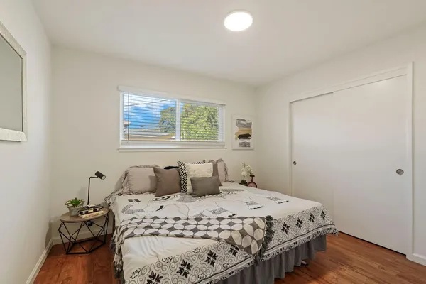 a bedroom with a bed and wooden floor