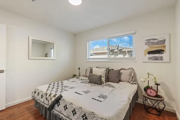 a bedroom with a bed and wooden floor