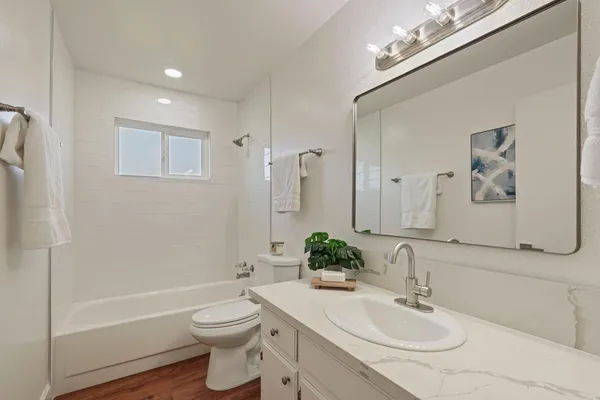 a bathroom with a toilet a sink a mirror and bathtub