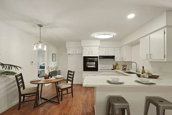 a kitchen with a dining table chairs microwave and refrigerator