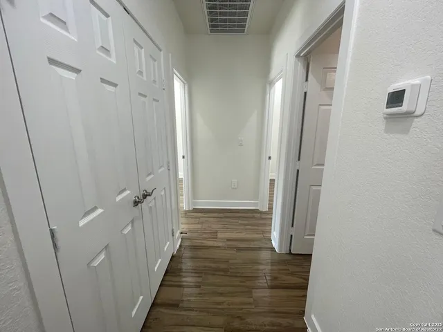 a view of a hallway with wooden floor and staircase
