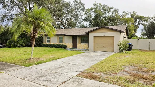 a front view of house with yard and trees around