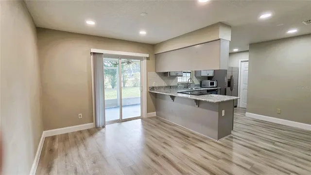 a large kitchen with stainless steel appliances granite countertop a large stove a sink and a microwave