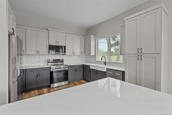 a kitchen with kitchen island granite countertop a stove top oven sink and window