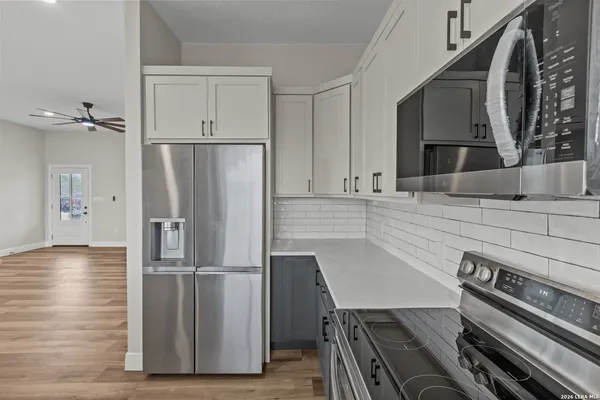 a kitchen with a refrigerator and a stove top oven