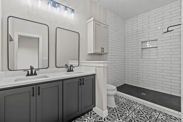 a bathroom with a granite countertop sink a toilet and a mirror