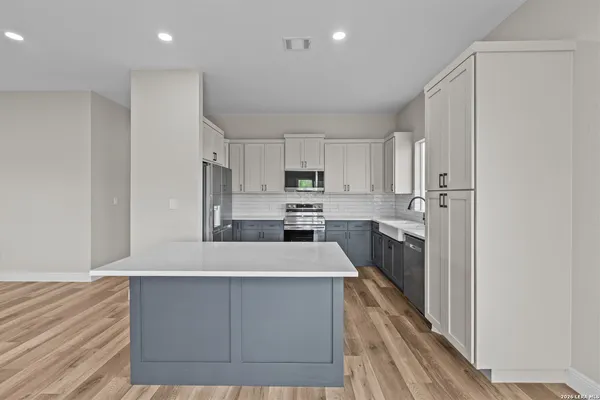 a large kitchen with stainless steel appliances a refrigerator and a stove