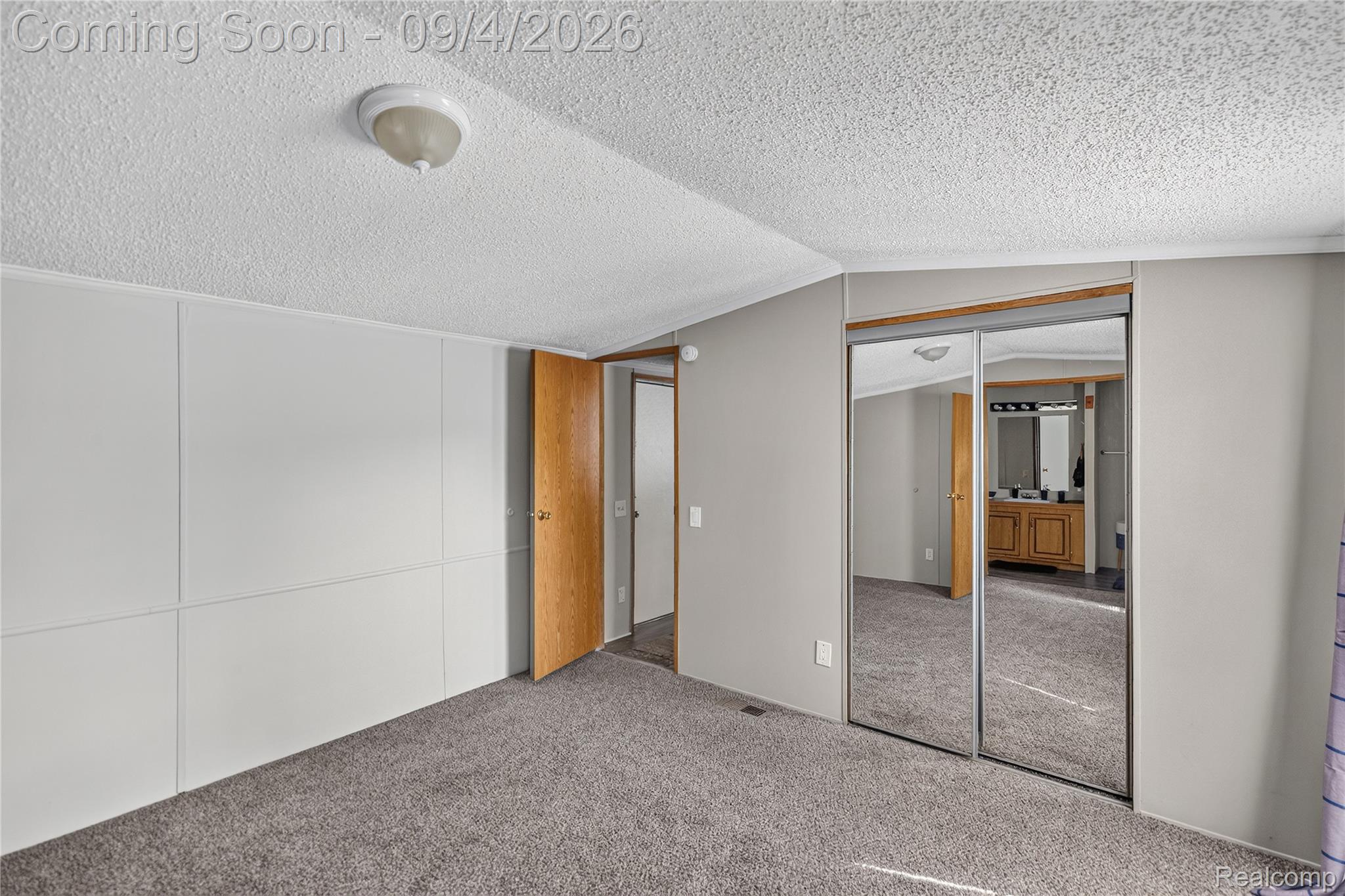 51074 Mott Road, Unit 200 Canton, MI 48188 - Photo 10 of 24 Carpeted flooring, mirrored sliding closet doors, wood-finish interior door, and paneling on walls