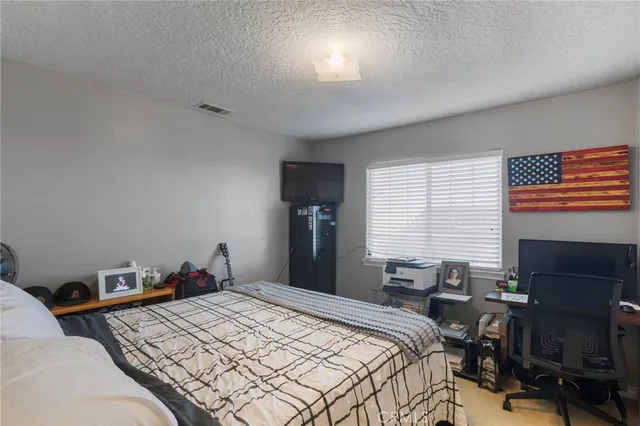 a bedroom with a bed and a computer on desk
