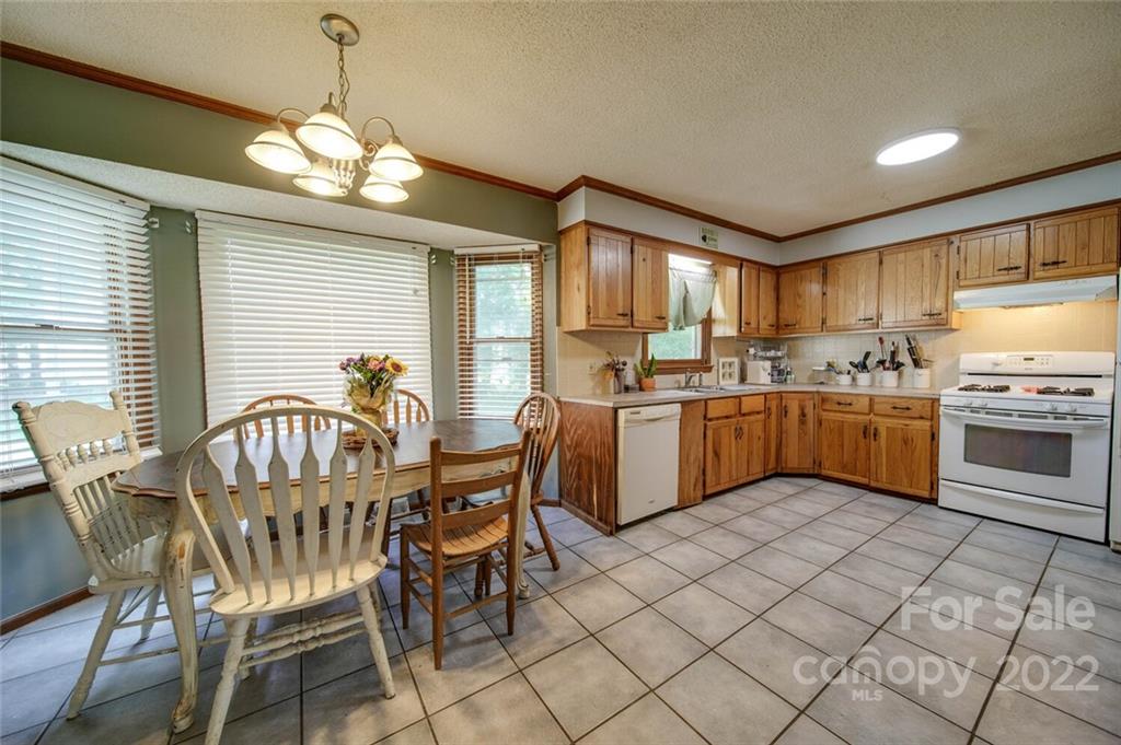 3210 Trinity Church Road Monroe, NC 28112 - Photo 21 of 29 a kitchen with stainless steel appliances kitchen island granite countertop a sink a stove a dining table and chairs
