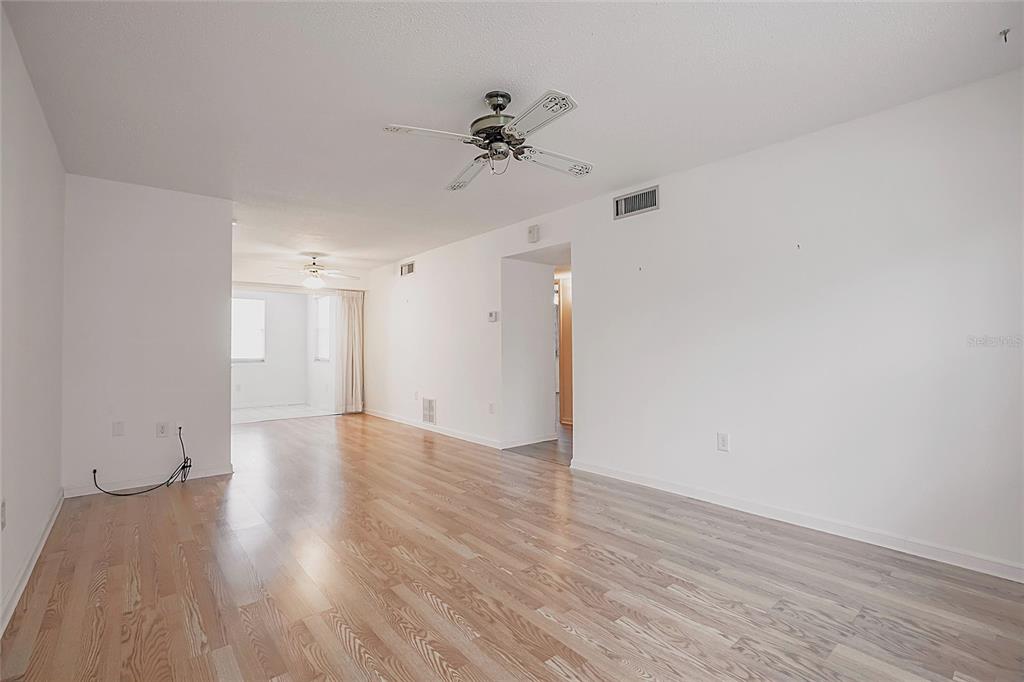 4158 Tamiami Trail, Unit S6 Port Charlotte, FL 33952 - Photo 3 of 39 a view of a room with wooden floor and a ceiling fan