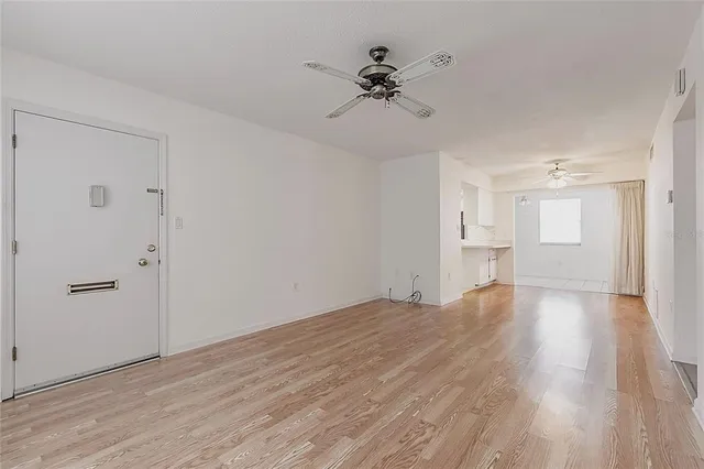 a view of empty room with wooden floor and window