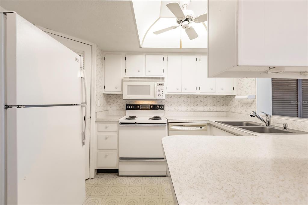 4158 Tamiami Trail, Unit S6 Port Charlotte, FL 33952 - Photo 7 of 39 a kitchen with stainless steel appliances cabinets a sink and a window