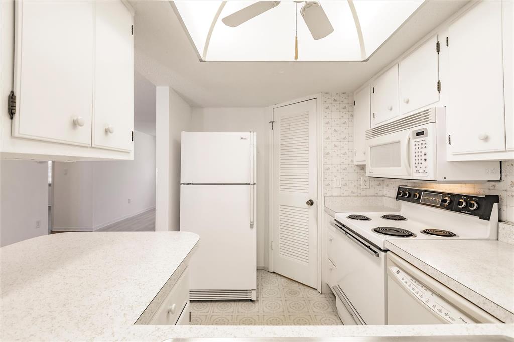 4158 Tamiami Trail, Unit S6 Port Charlotte, FL 33952 - Photo 8 of 39 a kitchen with kitchen island a stove a refrigerator a sink a counter space and cabinets