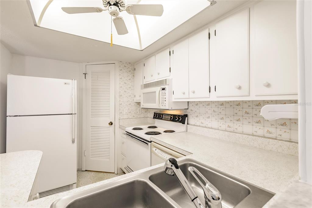4158 Tamiami Trail, Unit S6 Port Charlotte, FL 33952 - Photo 9 of 39 a kitchen with stainless steel appliances a refrigerator a stove a sink and white cabinets