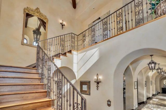 a view of staircase with railing and white walls