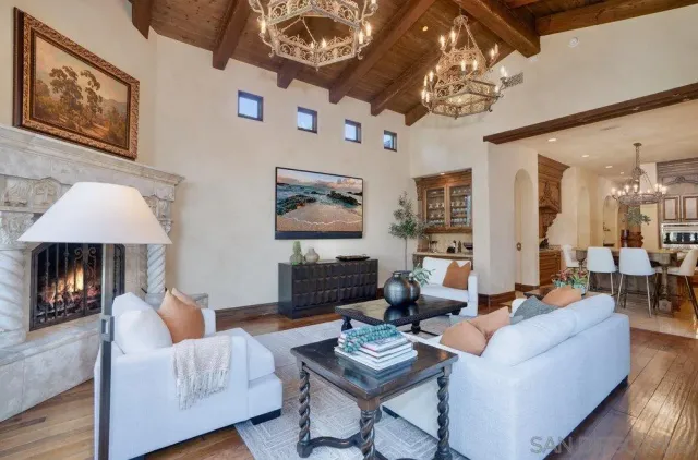 a living room with furniture a chandelier and a flat screen tv