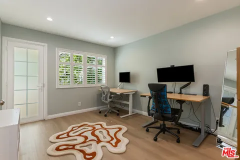 a view of a workspace with furniture and a window