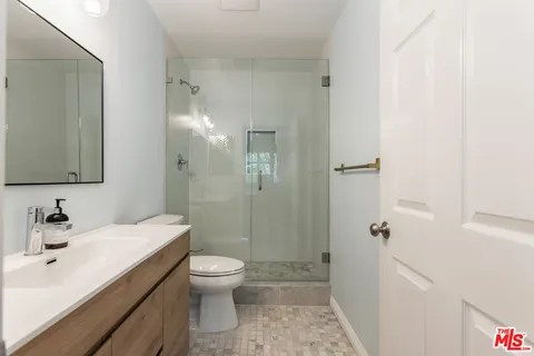 a bathroom with a sink a toilet and shower