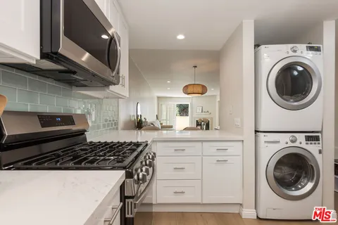a kitchen with granite countertop a sink and a stove top oven