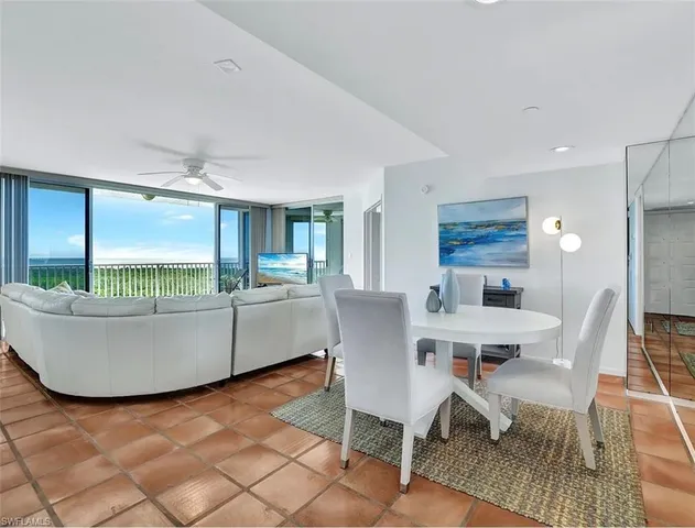 a living room with a table chairs and a dining table with wooden floor