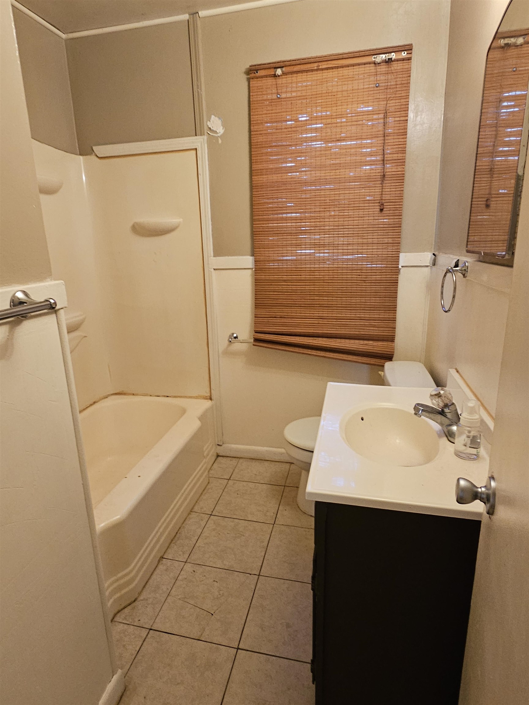 1196 Wells Station Road Memphis, TN 38122 - Photo 6 of 20 Full bathroom featuring light tile patterned floors, vanity, and washtub / shower combination