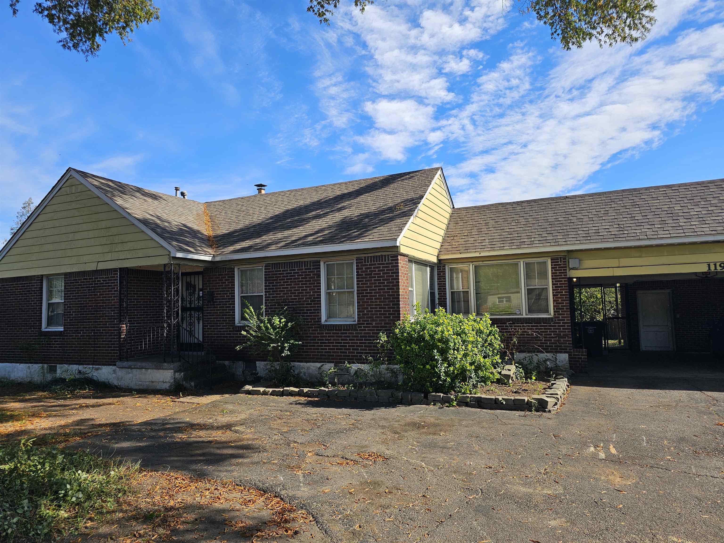 1196 Wells Station Road Memphis, TN 38122 - Photo 10 of 20 View of front of house with brick siding, a carport, asphalt driveway, roof with shingles, and a patio
