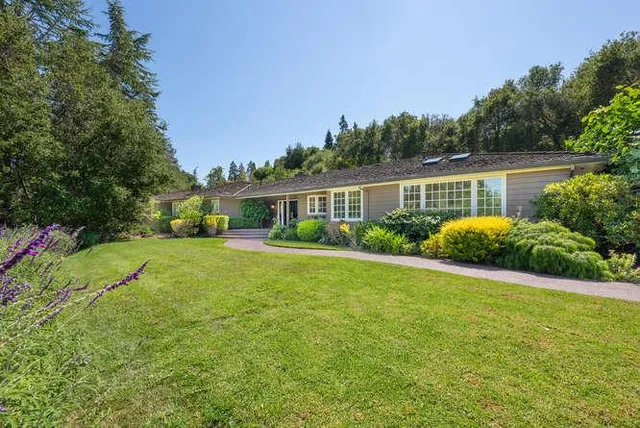 a view of a house with backyard and sitting area