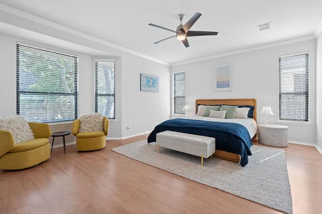 a bedroom with a large bed couch and windows