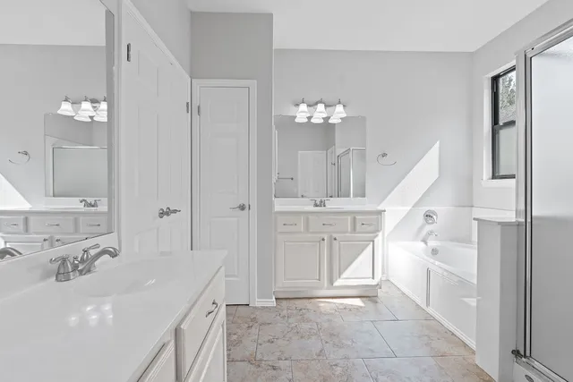 a spacious bathroom with a sink a mirror and a shower