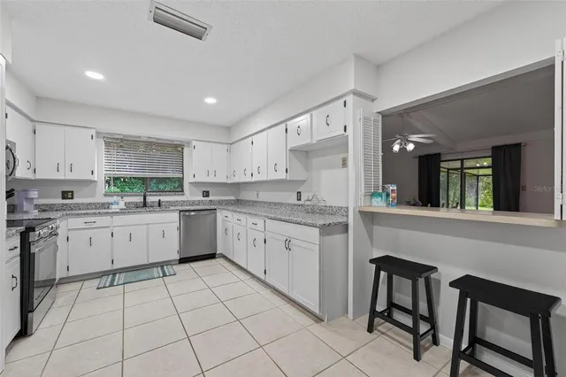 a kitchen with granite countertop appliances cabinets and a sink