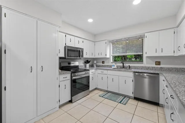 a kitchen with cabinets appliances a sink and a window