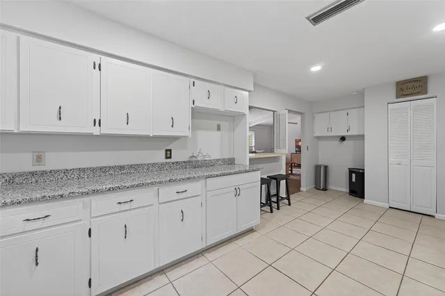 a kitchen with white cabinets appliances and a window