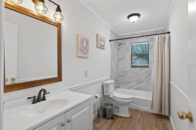 a bed sitting in a spacious bedroom next to a window