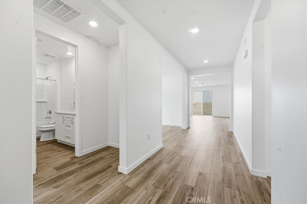 42957 56th Street West Lancaster, CA 93536 - Photo 14 of 40 a view of a hallway with wooden floor and a bathroom