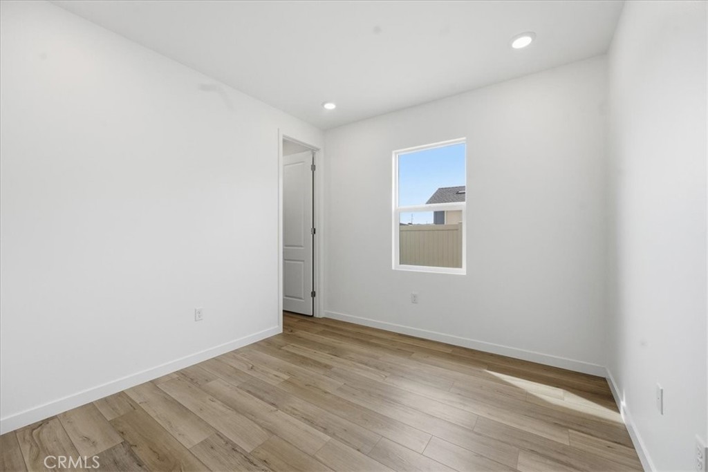 42957 56th Street West Lancaster, CA 93536 - Photo 16 of 40 an empty room with wooden floor and windows