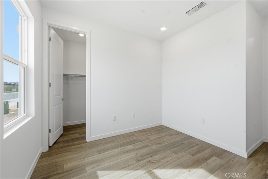 42957 56th Street West Lancaster, CA 93536 - Photo 19 of 40 an empty room with wooden floor and windows