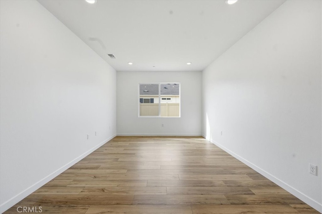 42957 56th Street West Lancaster, CA 93536 - Photo 20 of 40 an empty room with wooden floor and windows